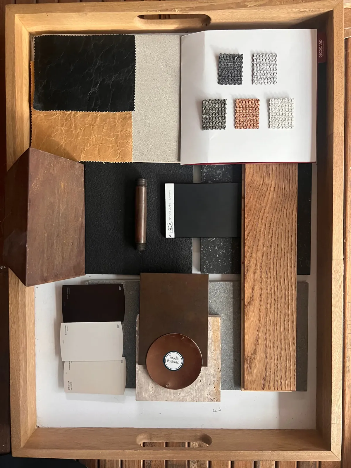 Bandeja de muestras de materiales con cuero, textiles, madera, piedra y metal para la selección de acabados y mobiliario